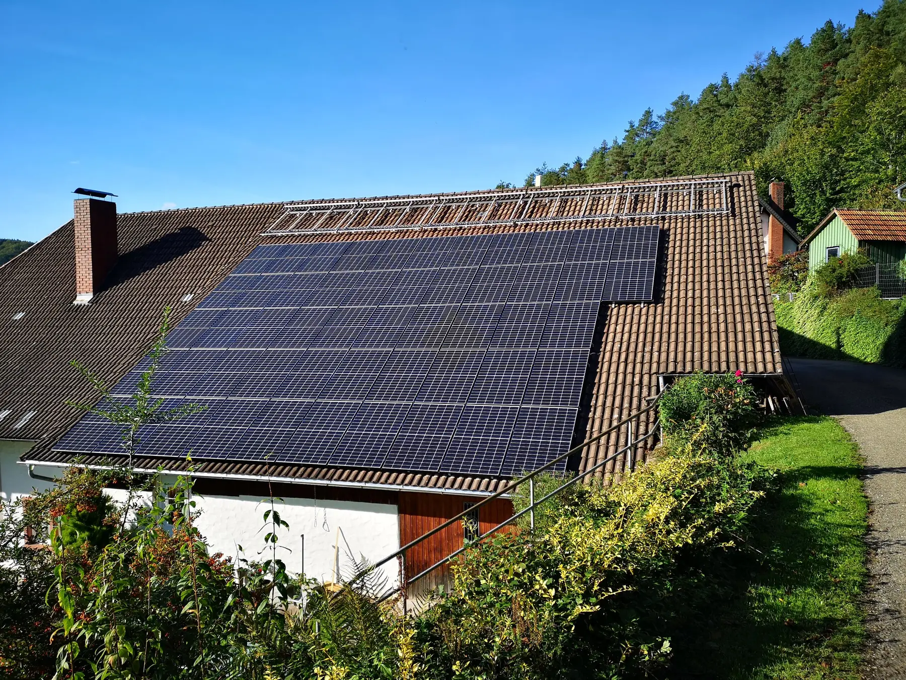 Photovoltaikanlage auf dem Ziegeldach eines Hauses am Waldhang im Kinzigtal