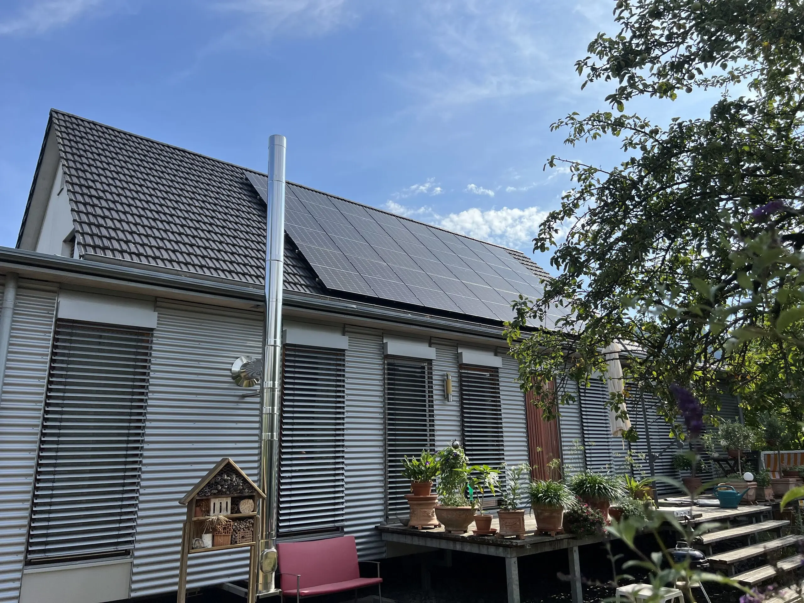 Modernes Wohnhaus mit schwarzer Photovoltaikanlage auf dem Dach